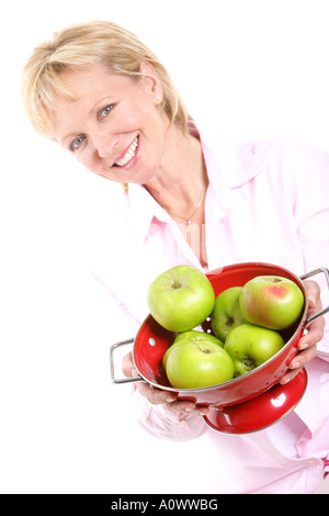 Reife Frau mit roten Sieb der Frische, grüne Äpfel kochen Isoliert gegen einen weißen Hintergrund mit einen Freistellungspfad Stockfoto