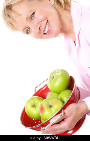 Reife Frau mit roten Sieb der Frische, grüne Äpfel kochen Isoliert gegen einen weißen Hintergrund mit einen Freistellungspfad Stockfoto