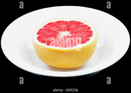 Die Hälfte eines frischen Reifen gesund saftig rosa Grapefruit vor einem schwarzen Hintergrund mit Keine Personen Stockfoto