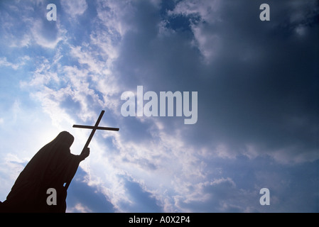 DAS KREUZ HALTEND Stockfoto