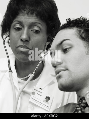 B&W Bild der Ärztin Prüfung jungen männlichen Patienten gegeben. Stockfoto