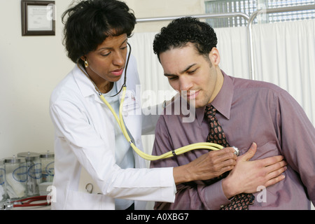 Ärztin verleiht Prüfung jungen männlichen Patienten. Stockfoto