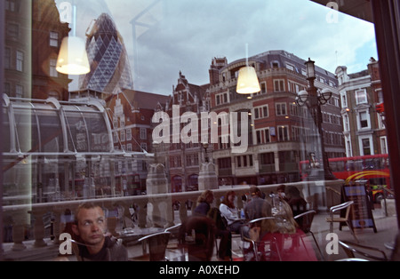 United Kingdom, England, London. Ein Kaffeetrinker bewundert die Skyline der Stadt, wie Sie sich im Fenster des café Stockfoto