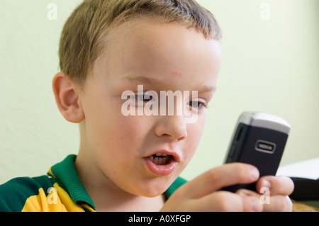 Junge spielt mit einem Nokia-Mobiltelefon Stockfoto