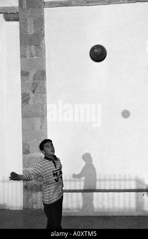 Griechenland LIPSI INSEL Junge Junge spielt Fußball seinen Schatten an der Wand Stockfoto