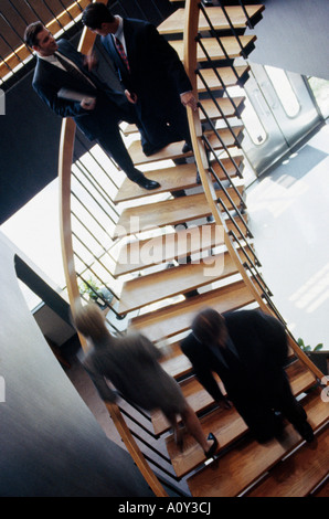 Erhöhte Ansicht der drei Geschäftsleute und eine Geschäftsfrau auf einer Treppe Stockfoto