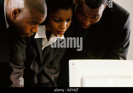 Nahaufnahme von zwei Geschäftsleute und eine Geschäftsfrau auf der Suche an einem computer Stockfoto