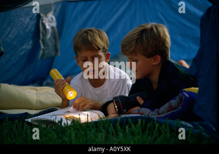 Zwei jungen ein Buch mit Hilfe einer Taschenlampe Stockfoto