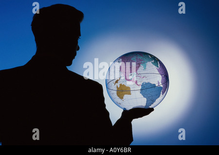 Silhouette eines Geschäftsmannes hält einen Globus Stockfoto
