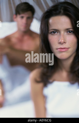Porträt einer jungen Frau mit einem jungen Mann hinter ihr Stockfoto