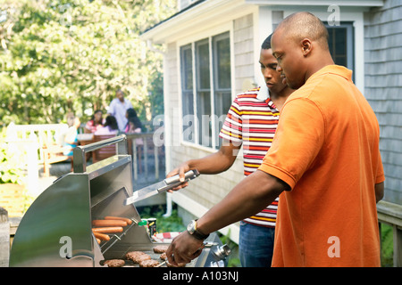 Junge afrikanische Männer Grillen Essen Stockfoto