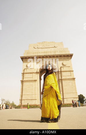 Niedrigen Winkel Blick auf eine junge Frau steht vor einem Denkmal, India Gate, Neu Delhi, Indien Stockfoto