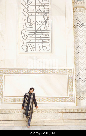 Junger Mann lehnte sich gegen eine Wand, Taj Mahal, Agra, Uttar Pradesh, Indien Stockfoto