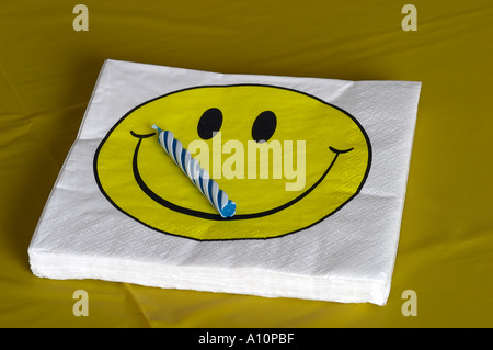 Smiley-Gesicht-Serviette auf Tisch mit Kerze bereit für party Stockfoto