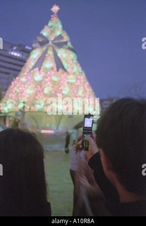 Besucher benutzen ihr Telefon, um einen Weihnachtsbaum in Roppongi Tokyo fotografieren Stockfoto