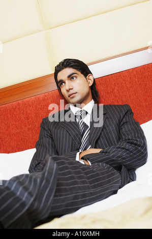 Niedrigen Winkel Ansicht eines Geschäftsmannes, liegend auf dem Bett Stockfoto