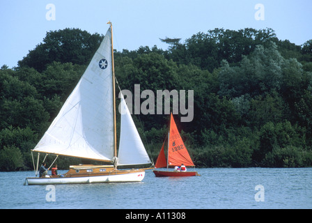 Zwei Boote unter Segel, river Cruiser und Beiboot, wroxham Broad, Norfolk, East Anglia England Großbritannien Stockfoto