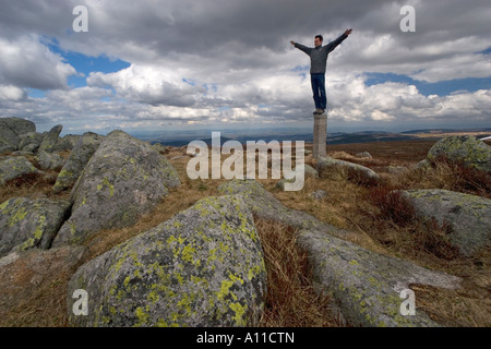 Mann seinen Gleichgewichtssinn auf einem Granit-Grenzstein (Frankreich) testen. Homme En Équilibre Sur Une de Granit (Frankreich) zu tragen. Stockfoto