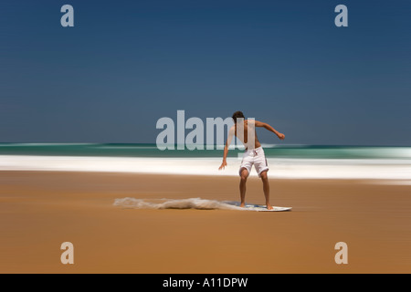 Ein Skimboarder auf Cordoama Strand, Algarve (Portugal).  Skimboarder Sur la Plage de Cordoama, de Algarve (Portugal). Stockfoto