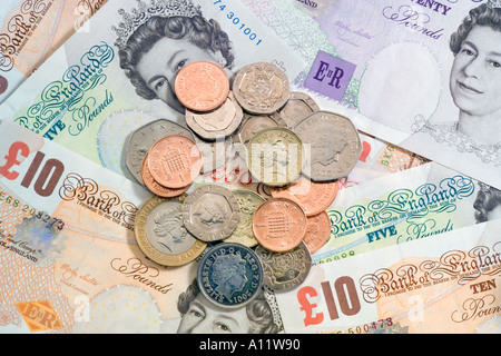 Haufen von UK britischen Münzen auf britische Banknoten Stockfoto