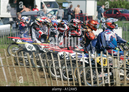 die Konkurrenten Line-up in der Startaufstellung hinter Holzzaun bei Tandragee Motocross Strecke County down Northern Irland Stockfoto
