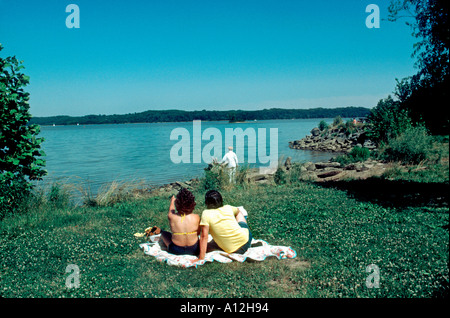 Malerische USA, Washington DC (Bereich) junge romantisch zu zweit entspannen in Grass in der Nähe von Lake Stockfoto