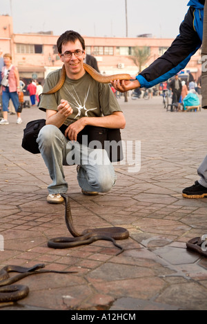 Touristischen posiert mit einem Schlangenbeschwörer Schlange im Markt Djemaa el-Fna in Marrakesch Marokko Stockfoto