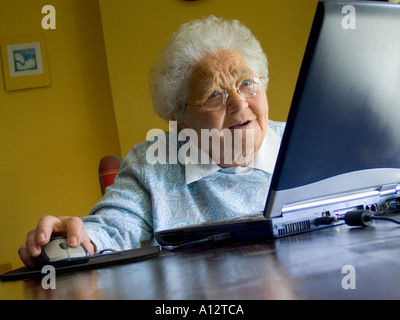 Ältere ältere Dame und Computer zu Hause, die ihre neue Technologie verwenden, ist fasziniert von ihrem neuen Laptop-Bildschirm und von den Möglichkeiten, die sie nutzen und nutzen. Stockfoto