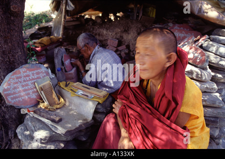 Tibetisch-buddhistische Nonne wartet ein Mani-Stein gemeißelt in McLeod Ganj, Dharamsala, Nordindien - Heimat des Dalai Lama Stockfoto