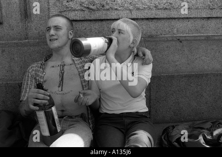 Skinheads ein Paar trinkt Alkohol aus einer Flasche der Mann hat ein Tattoo von Christus als Skinhead gekreuzigt auf seiner Brust London 1982 1980s UK HOMER SYKES Stockfoto