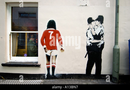 Banksys berühmten kissing Coppers plus ein George Best Rückansicht, an einer Wand in Brighton. Stockfoto