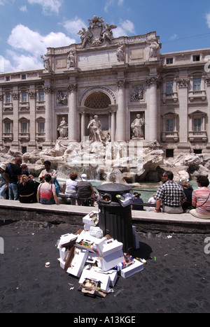 Touristen, die den berühmten historischen, geschäftigen italienischen Trevi-Brunnen besuchen, Statuen und Skulpturen, die sich neben einem überfließenden Abfalleimer in Rom, Italien, stapelten Stockfoto