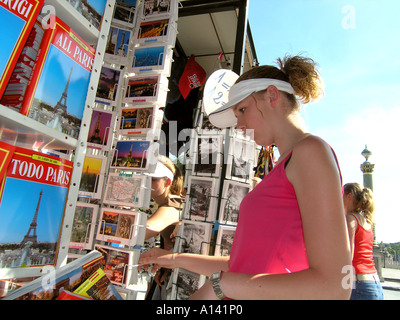 Teenager-Mädchen Surfen auf Postkarten von Paris Frankreich Stockfoto