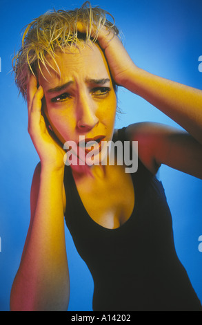 BLONDE HAARE FRAU, DIE KOPFSCHMERZEN. HALTEN SIE IHREN KOPF Stockfoto