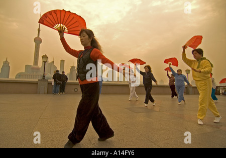 Frauen, die Morgen üben mit ihren traditionellen chinesischen Fans auf dem Bund in Shanghai, China. Stockfoto