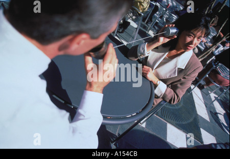 Zwei Geschäftsleute draußen sprechen über eine Zeichenfolge zwischen zwei Blechdosen Stockfoto