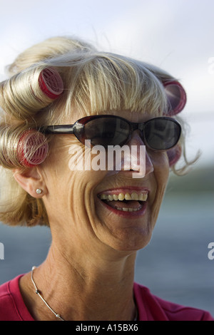 Porträt der älteren Frau mit Lockenwickler und Sonnenbrillen Stockfoto