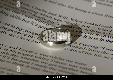 Horizontale Nahaufnahme des Bräutigams eingeschrieben Platin Ehering und seine gedruckten Rede bereit für seine Hochzeit. Stockfoto