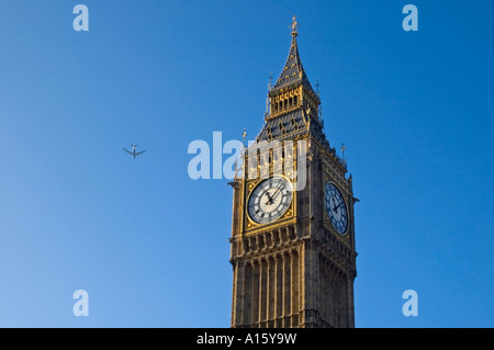 Horizontale Ansicht des dekorativen Ziffernblattes von Big Ben mit einem Flugzeug fliegen bestanden in den klaren blauen Himmel. Stockfoto