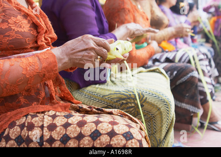 Sitzende Frauen, die er Blatt Körbe Stockfoto