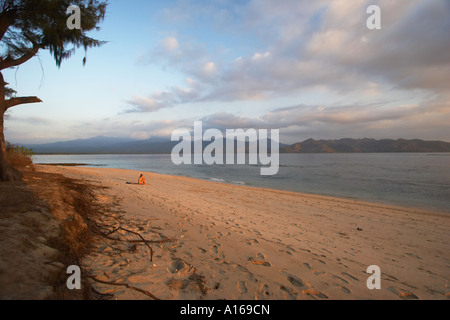 Einsame Frau sitzt am tropischen Strand Stockfoto