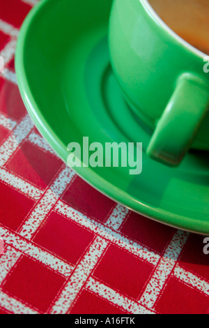 Grüner Kaffee Tasse und Untertasse auf rot gestreift Tischdecke Stockfoto