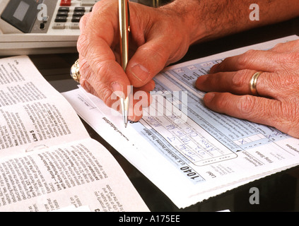 Mann, die Einkommensteuer-Formulare ausfüllen Stockfoto