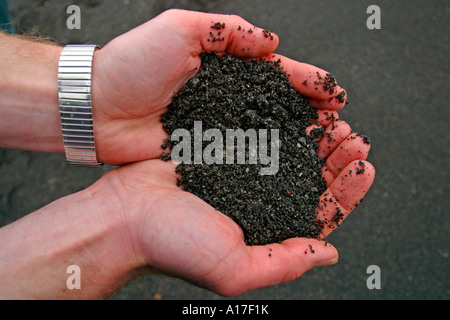 Eine Hand mit schwarzen Vulkanerde. Stockfoto