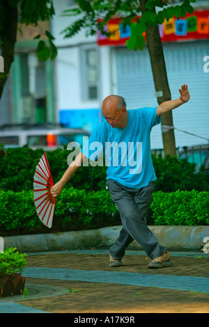 Ein älterer Mann praktiziert Tai Chi in einem Park in Hong Kong. Stockfoto
