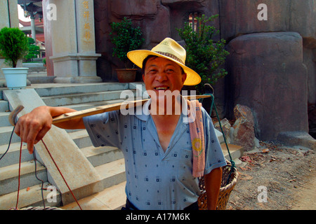 Ein glücklicher chinesischen Mann lächelt, als er eine Zigarette raucht. Stockfoto