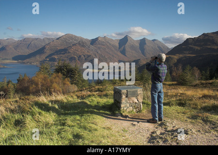 horizontale Landschaftsfoto eines Mannes Blick durch ein Fernglas auf den Blick über Loch Duich die fünf Schwestern von kintail Stockfoto