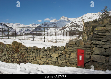 horizontale Foto von Schnee bedeckt Great Langdale im Lake District mit leuchtend roten royal Mail-Briefkasten in der Trockenmauer Stockfoto