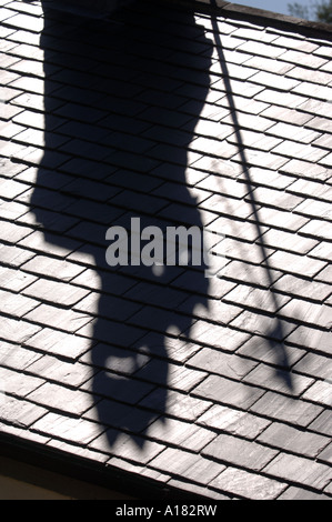 DER SCHATTEN VON EINEM SCHORNSTEIN WIRFT EINEN SCHEINBAR DÄMONISCHEN SCHATTEN ÜBER EIN SCHIEFERDACH UK Stockfoto