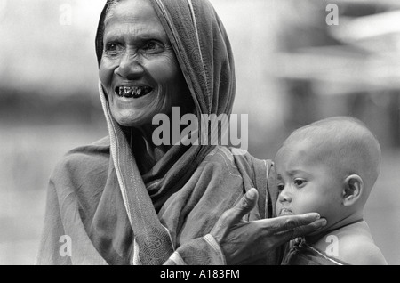 B/W-Porträt einer Großmutter, die stolz ihren Babyenkel aus einem Bauerndorf in der Nähe von Tangail, Bangladesch, zeigt Stockfoto